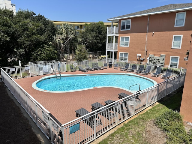 community pool with fence and a patio