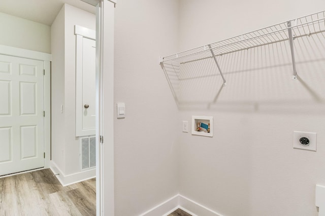 clothes washing area with hookup for a washing machine, light hardwood / wood-style floors, and hookup for an electric dryer