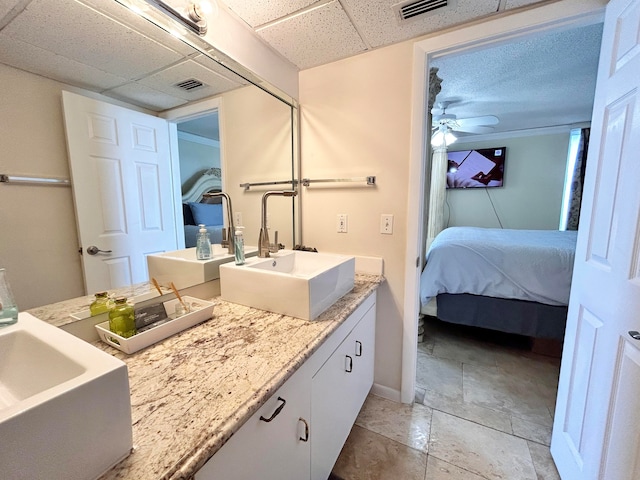 bathroom featuring a paneled ceiling, ceiling fan, and vanity