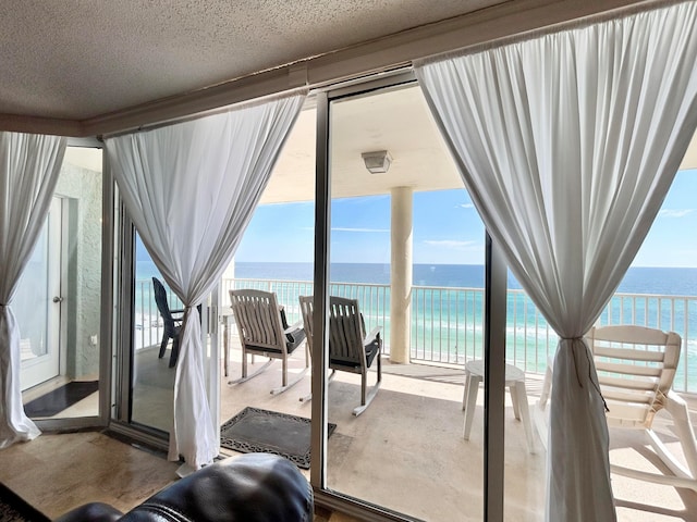 interior space featuring a water view, a textured ceiling, and a wealth of natural light