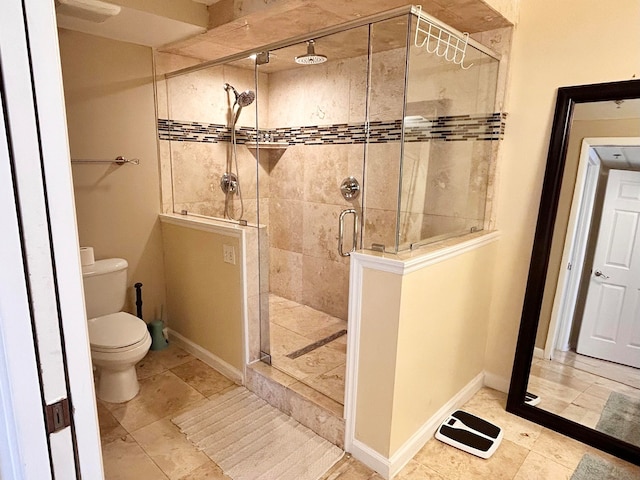 bathroom with a shower with shower door and toilet