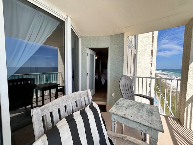 balcony featuring a beach view and a water view