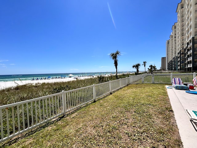 view of yard featuring a water view and a beach view