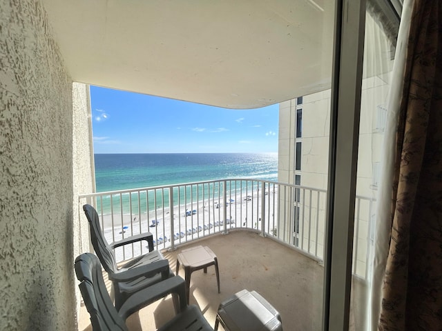 balcony with a water view and a beach view