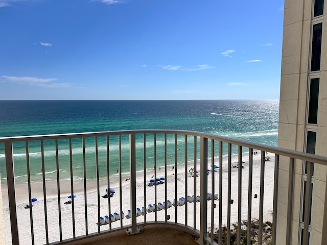 balcony featuring a water view and a beach view