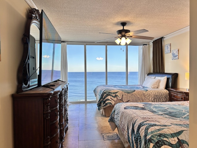 bedroom with access to exterior, expansive windows, a textured ceiling, ceiling fan, and crown molding