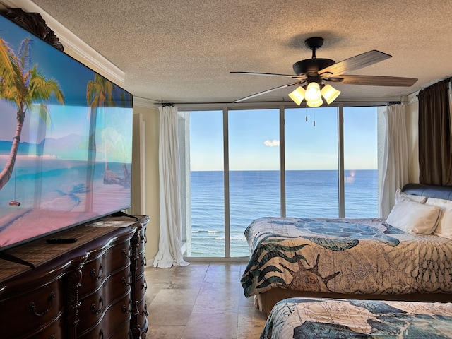 bedroom with expansive windows, a water view, ceiling fan, and access to outside