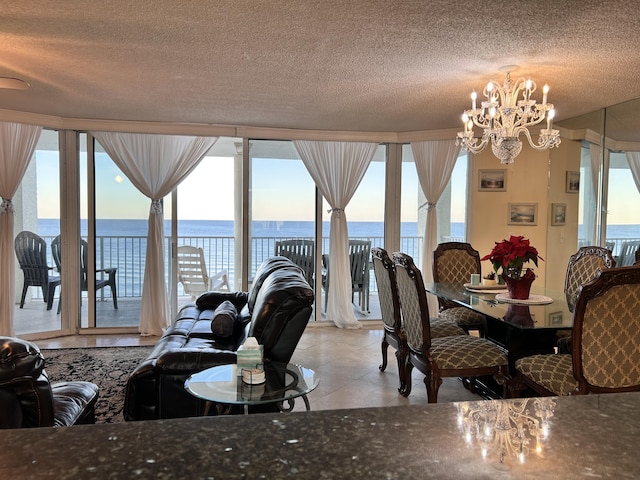 tiled dining space featuring a water view, a textured ceiling, and a chandelier