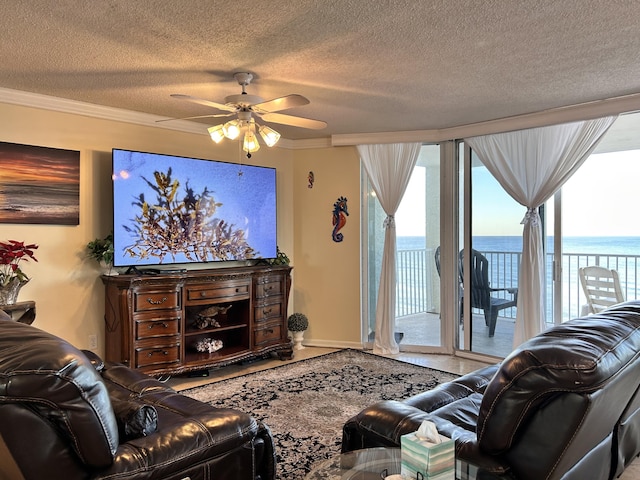 living room with a textured ceiling, ceiling fan, and crown molding