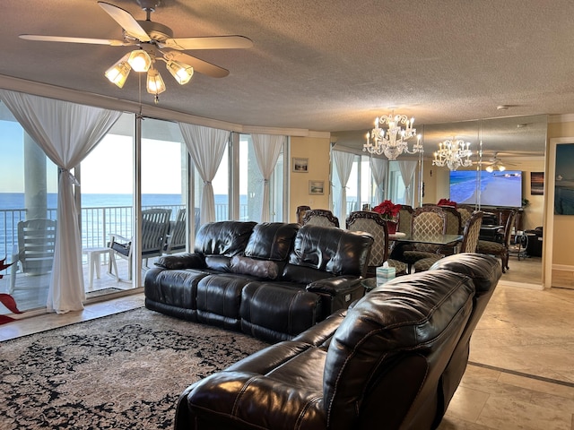 living room with ceiling fan with notable chandelier, a water view, and a textured ceiling