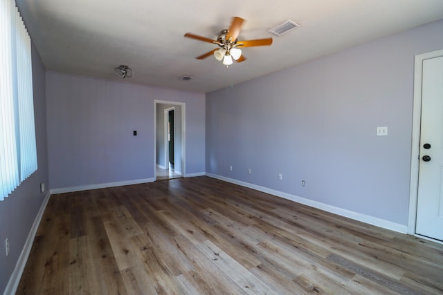 empty room with ceiling fan and light hardwood / wood-style floors