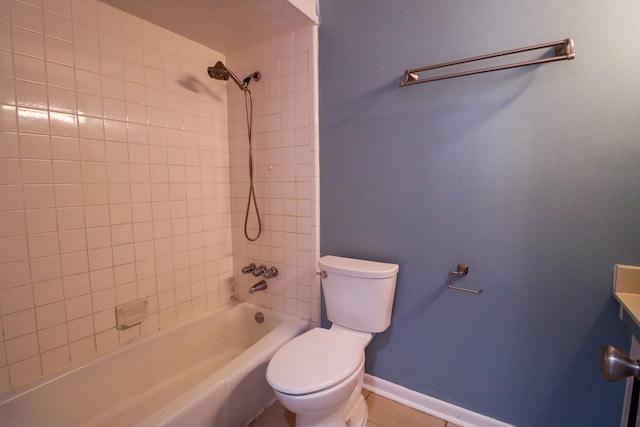 full bathroom with tiled shower / bath combo, toilet, tile patterned flooring, and vanity