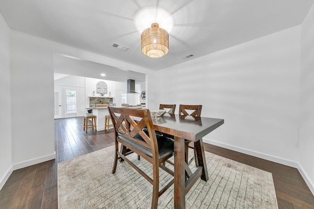 dining room featuring baseboards, visible vents, and dark wood finished floors