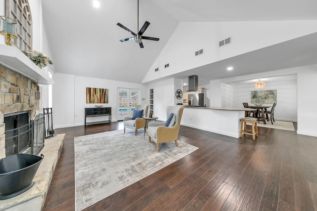 living room featuring baseboards, a fireplace, visible vents, and dark wood finished floors