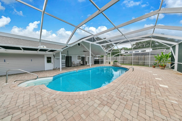 view of swimming pool featuring ceiling fan, glass enclosure, and a patio