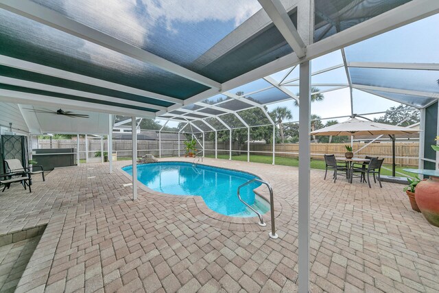 view of pool featuring ceiling fan, glass enclosure, and a patio area