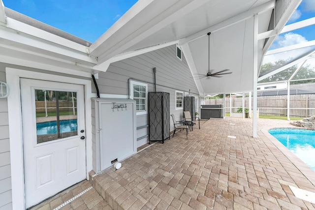 view of patio with a hot tub, a fenced in pool, ceiling fan, a lanai, and fence