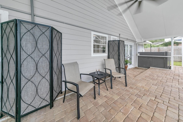 view of patio / terrace featuring a ceiling fan, fence, and a hot tub