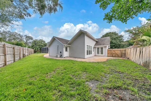 rear view of house with a patio area and a lawn