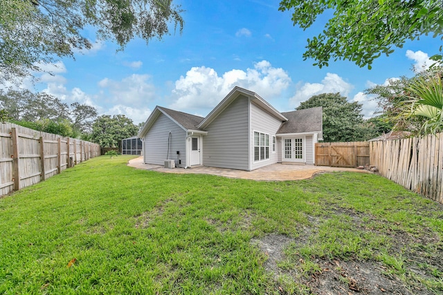 rear view of house featuring french doors, a patio area, a lawn, and a fenced backyard