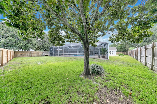 view of yard with a lanai and a fenced backyard