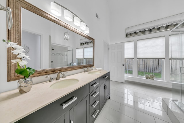 bathroom with tile patterned flooring, an enclosed shower, and vanity