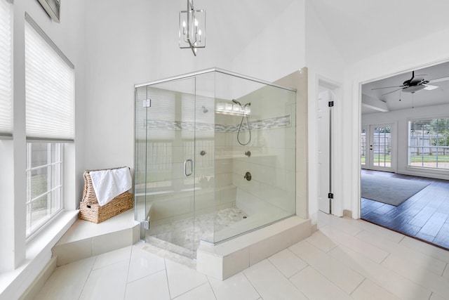 full bath featuring a stall shower, tile patterned flooring, and ceiling fan with notable chandelier