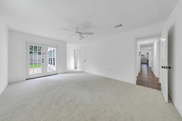 spare room featuring french doors, visible vents, carpet flooring, ceiling fan, and baseboards