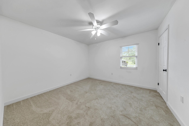 unfurnished room featuring baseboards, a ceiling fan, and light colored carpet