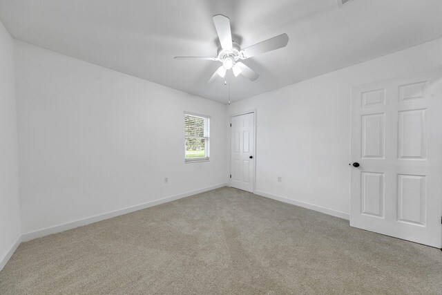 carpeted empty room featuring ceiling fan