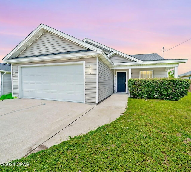 ranch-style home with a yard and a garage