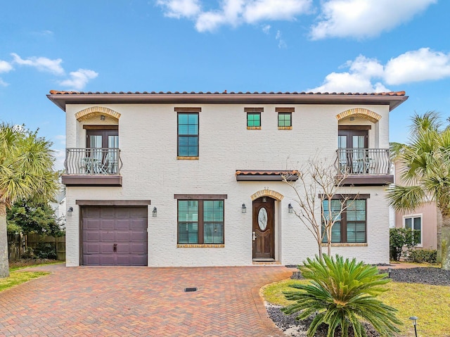 mediterranean / spanish-style house with a garage and a balcony