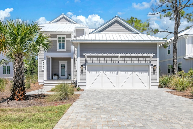 view of front of house featuring a garage, decorative driveway, metal roof, and a standing seam roof