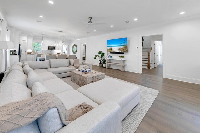 living room featuring ceiling fan, crown molding, and wood-type flooring