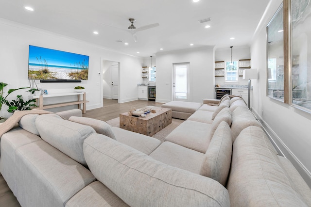 living room with light hardwood / wood-style flooring, ceiling fan, wine cooler, and ornamental molding