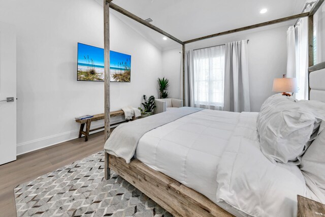 bedroom with light hardwood / wood-style floors and vaulted ceiling