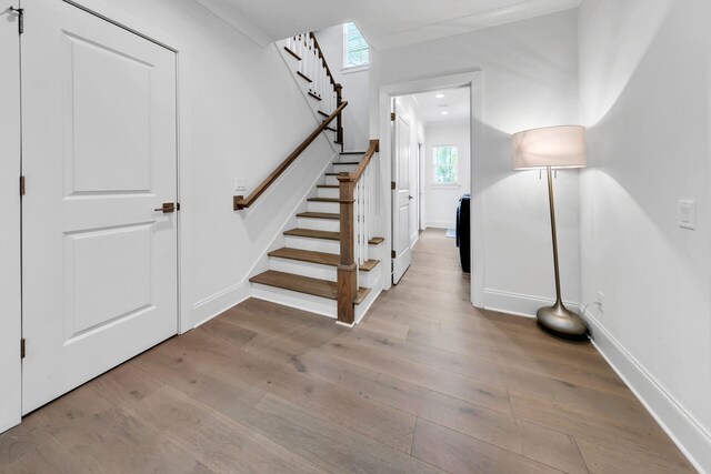 staircase featuring ornamental molding and wood-type flooring