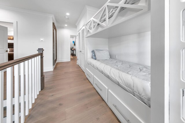 bedroom with crown molding and light wood-type flooring