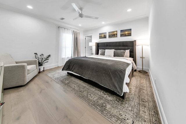 bedroom featuring ceiling fan, light wood-type flooring, and ornamental molding