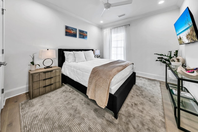 bedroom featuring ceiling fan, light hardwood / wood-style floors, and ornamental molding