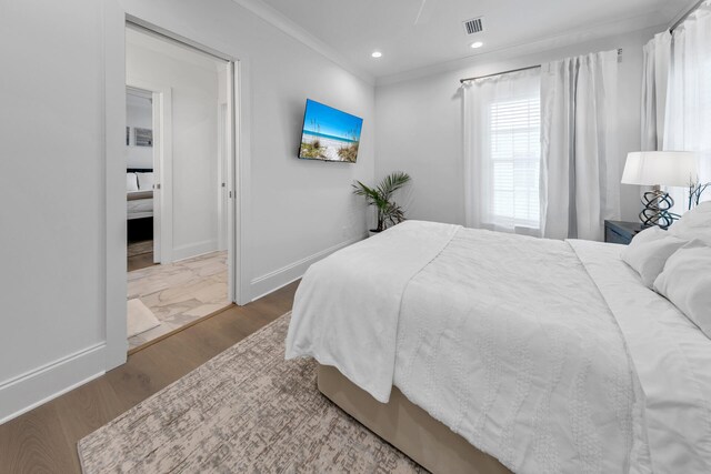 bedroom with hardwood / wood-style floors and ornamental molding