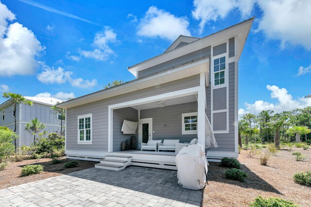 rear view of property featuring a patio and outdoor lounge area