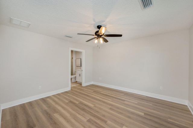 empty room featuring light hardwood / wood-style floors, ceiling fan, and a textured ceiling