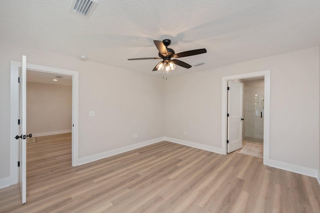 empty room featuring a textured ceiling, ceiling fan, and light hardwood / wood-style floors