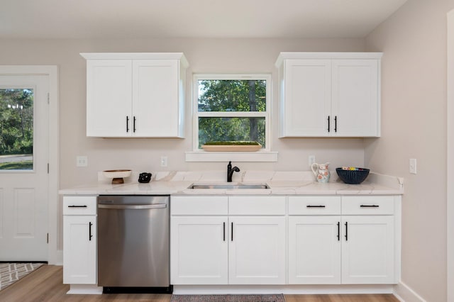 kitchen featuring light stone countertops, stainless steel dishwasher, light wood-type flooring, white cabinetry, and sink