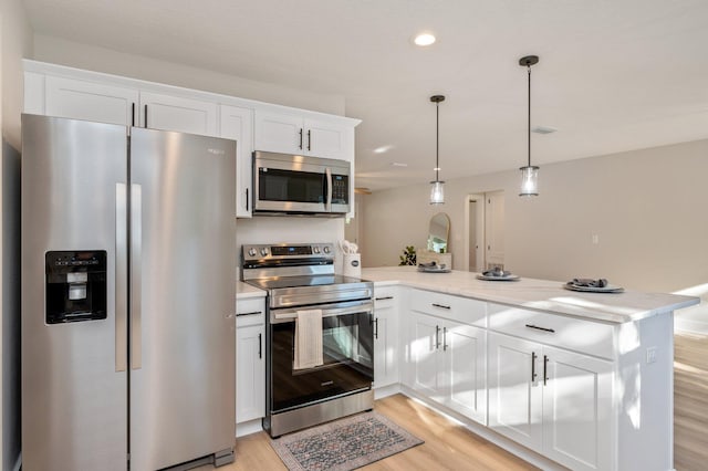 kitchen with white cabinetry, kitchen peninsula, and appliances with stainless steel finishes