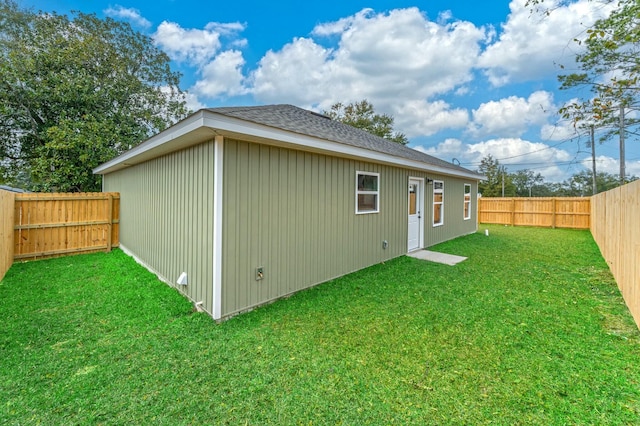 rear view of property featuring a lawn