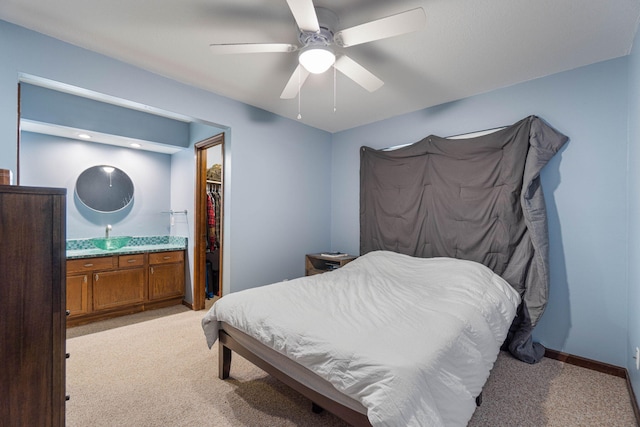 bedroom featuring light carpet, ceiling fan, connected bathroom, and baseboards