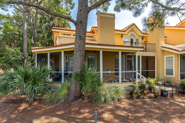 view of front of property featuring a sunroom and a balcony