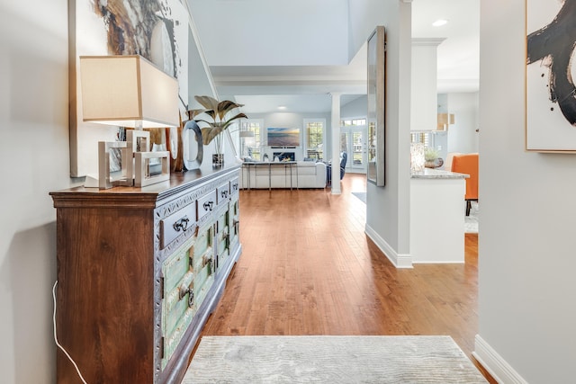 hallway featuring hardwood / wood-style flooring and ornate columns